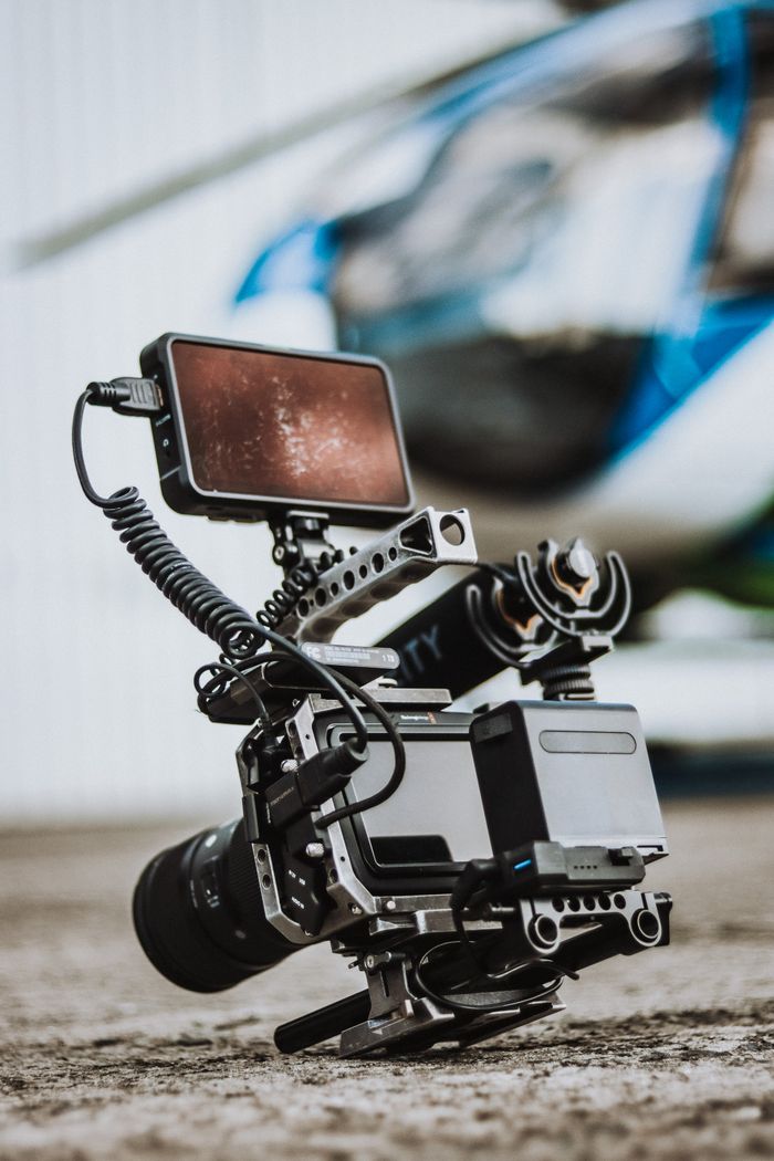 High-quality video rig on set, with a helicopter in soft focus background.